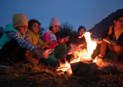Kinder machen nach einer Wanderung ein Picknick am Lagerfeuer